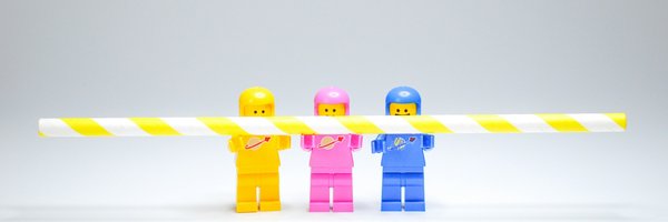 Drei Legofiguren halten einen Strohalm