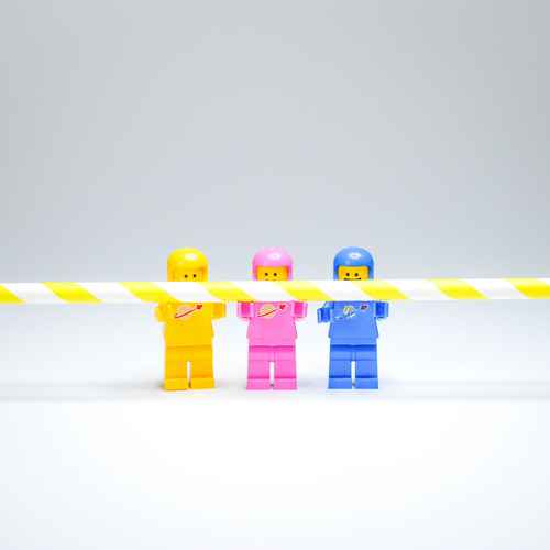 Drei Legofiguren halten einen Strohalm
